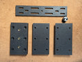 Set of black 3D printed brackets and hardware on a brown cardboard background